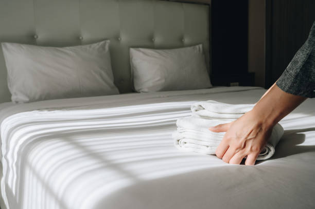 Conceptual shot of hotel maid preparing bed for customer.